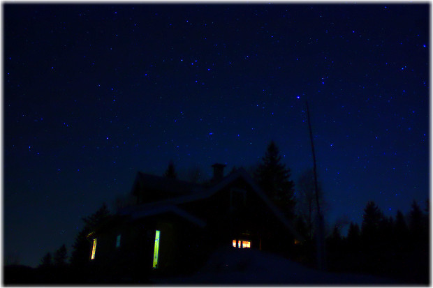 La cabaña posando con el cielo lleno de estrellas